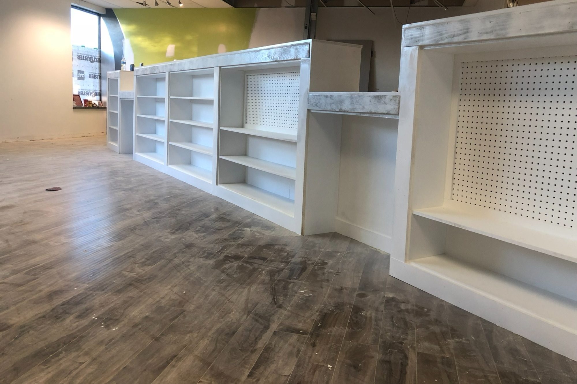 White modular shelving units arranged in a spacious, well-lit room.