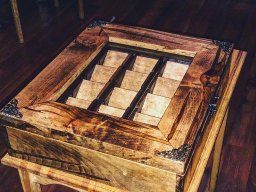 A wooden box with multiple compartments and an ornate frame design.