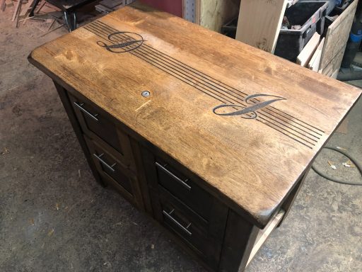 A wooden table with a grain pattern and decorative carving on the surface.
