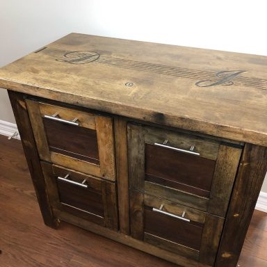 Wooden cabinet with four drawers, featuring a rustic design and metal handles.