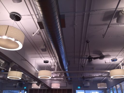 Modern ceiling with circular light fixtures and exposed ductwork.