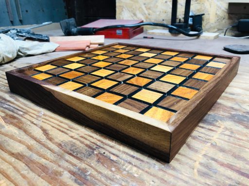 Wooden game board featuring a checkerboard pattern with various shades of wood.