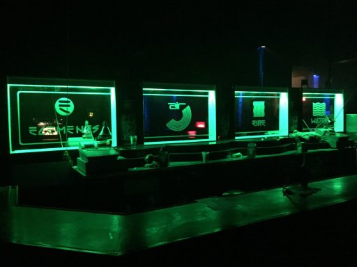 Futuristic bar with glowing green accents and digital screens.