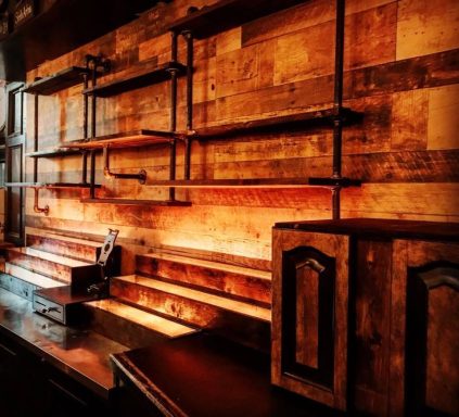 Rustic wooden wall with industrial shelving and warm lighting.