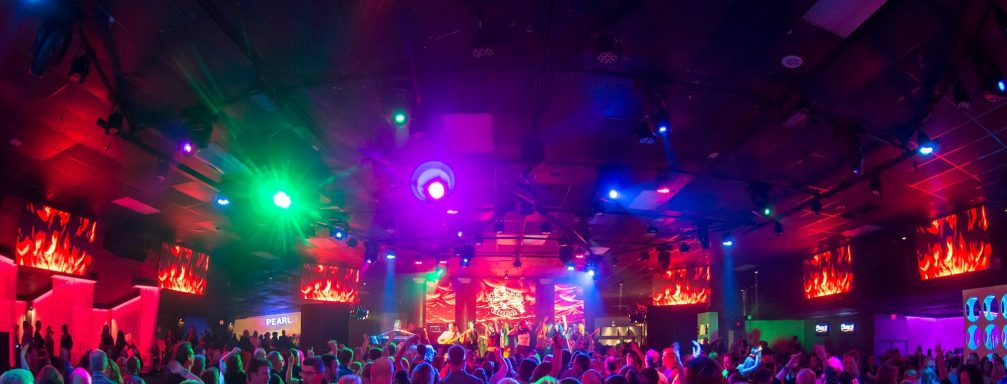 Vibrant nightclub scene with colorful lights and a crowded dance floor.