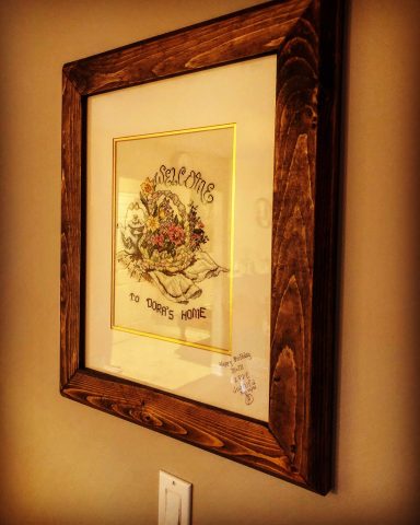 Framed artwork featuring floral designs and decorative text on a wall.